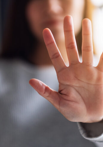 Closeup image of a woman outstretched hand and showing stop hand
